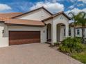 Charming single-story home featuring a tile roof, two-car garage, and inviting front yard with lush landscaping at 5329 Windy Grove Dr, Wimauma, FL 33598