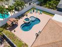Aerial view of a backyard featuring a modern pool, spa, brick patio, covered bar, and seating area at 5921 Denver Ne St, St Petersburg, FL 33703
