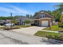 A two-story home with a one car garage, a tidy yard, and a paved driveway at 6616 Northhaven Ct, Riverview, FL 33578