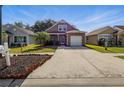 A neat two-story home with an attached garage and a long driveway in a suburban neighborhood at 6616 Northhaven Ct, Riverview, FL 33578