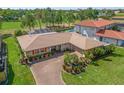 Aerial view of the property with well maintained lawn and landscaping, pool, and brick driveway at 6790 Burning Tree Dr, Seminole, FL 33777
