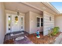 Inviting front entrance with decorated white door, beautiful brick flooring, and decorative lattice at 6790 Burning Tree Dr, Seminole, FL 33777