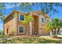 Attractive two-story home showcasing manicured landscaping, palm trees, and a well-maintained lawn at 7102 W Creek Dr, Tampa, FL 33615