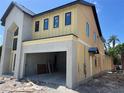 View of the new construction's side, highlighting the modern siding and attached two-car garage at 812 W Braddock St, Tampa, FL 33603