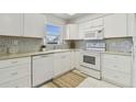 Bright kitchen featuring white cabinets, modern appliances, and decorative tile backsplash at 854 Sky Loch N Dr, Dunedin, FL 34698