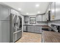 Bright kitchen features gray cabinets, butcher block counters, stainless steel appliances, and stylish subway tile backsplash at 8648 78Th Pl, Seminole, FL 33777