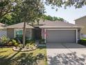 Charming single-story home with a gray exterior, lush landscaping, and an attached two-car garage at 5754 Sweet William Ter, Land O Lakes, FL 34639