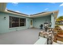 A welcoming light-blue porch with stone pillars, stylish lighting, and a comfortable outdoor seating area at 1023 Springtime Dr, Holiday, FL 34691