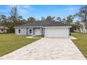Charming single-story home with a paved driveway, attached garage, and well-manicured lawn at 10262 Maybird Ave, Weeki Wachee, FL 34613