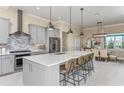 Stylish kitchen featuring gray cabinetry, a center island with seating, stainless steel appliances, and a mosaic backsplash at 11423 Shoreline Trl, Parrish, FL 34219