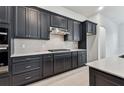 Stylish kitchen boasts dark cabinets, a gas range, and tile backsplash for a modern look at 11423 Shoreline Trl, Parrish, FL 34219