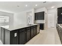 Spacious kitchen with dark cabinetry, a large island, and stainless steel appliances at 11423 Shoreline Trl, Parrish, FL 34219