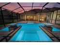 Inviting screened-in pool area with a spa, patio seating and beautifully landscaped backyard at 15229 Wind Whisper Dr, Odessa, FL 33556