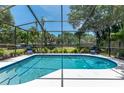 Screened pool with lounge chairs offers a private backyard oasis with tropical landscaping at 1628 12Th Sw St, Largo, FL 33778