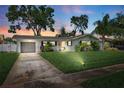 Charming home features a manicured lawn, painted exterior, and lush tropical landscaping at 1648 Arbor Dr, Clearwater, FL 33756