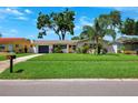 Charming home features a manicured lawn, painted exterior, and lush tropical landscaping at 1648 Arbor Dr, Clearwater, FL 33756