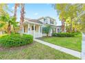 Beautiful two-story home with a manicured lawn and lush landscaping along a sidewalk at 20121 Bending Creek Pl, Tampa, FL 33647