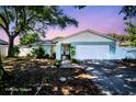 Charming single-story home featuring light blue exterior, well-maintained landscaping, and a two-car garage at 2366 Covington Dr, Clearwater, FL 33763