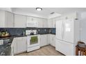 Clean kitchen with white cabinetry, stone countertops, and stainless steel appliances at 2366 Covington Dr, Clearwater, FL 33763