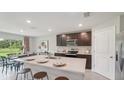 Modern kitchen boasts a large island with seating, stainless steel appliances, and adjacent dining area at 3338 Ivy Hollow Dr, Plant City, FL 33565