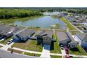 Aerial view showcasing a two-story home near a lake, highlighting its community setting at 35853 Buttonweed Trl, Zephyrhills, FL 33541