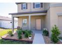 Inviting front porch with a decorative garden, enhancing the home's curb appeal at 35853 Buttonweed Trl, Zephyrhills, FL 33541
