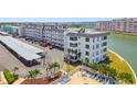 A white condo complex features a swimming pool and palm trees with water views at 5960 30Th S Ave # 414, Gulfport, FL 33707