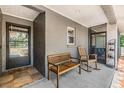 Inviting front porch featuring a bench, rocking chair, and screened entry, perfect for relaxation at 6821 Mary Lou Ln, Wesley Chapel, FL 33544