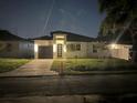 Single-Gathering home featuring a modern design, a well-manicured lawn and warm lighting at 7208 N Glen Ave, Tampa, FL 33614