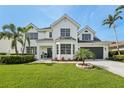 Elegant two-story home with lush lawn, manicured landscaping and paver driveway at 750 Sand Pine Ne Dr, St Petersburg, FL 33703