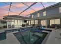 Screened in pool features a spa, outdoor kitchen, TV and ample seating at 750 Sand Pine Ne Dr, St Petersburg, FL 33703