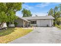 Inviting single-story home showcasing a stone facade, landscaped front yard, and paved driveway at 7714 Bayleaf Dr, Hudson, FL 34667