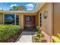 Inviting front entrance with double doors, decorative wreath, and manicured landscaping at 785 Hickory Ln, Palm Harbor, FL 34683