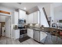 Modern kitchen features stainless steel appliances, granite countertops, and white cabinetry at 10742 Verawood Dr, Riverview, FL 33579