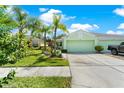 Exterior shot of single-Gathering home with two-car garage, landscaped front yard, and sidewalks at 11466 Captiva Kay Dr, Riverview, FL 33569