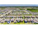 Aerial view of a neighborhood with neatly arranged homes and community amenities like lakes and parks at 15718 Fort Island Pl, Sun City Center, FL 33573