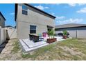 Home's backyard featuring a tiled patio with seating, landscaping, and open green space at 15718 Fort Island Pl, Sun City Center, FL 33573