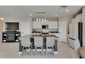 Bright kitchen featuring a central island with seating, modern appliances, and sleek countertops at 15718 Fort Island Pl, Sun City Center, FL 33573