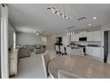 Bright, open-concept living room featuring modern lighting, tile floors, and a comfortable sectional sofa at 15718 Fort Island Pl, Sun City Center, FL 33573