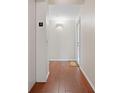 Neutral condo hallway featuring wood floors, white walls, and an inviting entrance door at 1695 Pinellas Bayway S # E6, St Petersburg, FL 33715