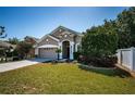 Beautiful single-story home with a well-kept lawn, garden bed, and an attached garage at 19610 Sunset Bay Dr, Land O Lakes, FL 34638