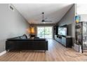 Inviting living room featuring sleek wood floors, a modern ceiling fan, and sliding glass doors at 3039 Sean Way, Palm Harbor, FL 34684