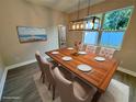 Elegant dining room featuring a stylish light fixture and a wood table set for six, perfect for Gathering gatherings at 37565 Teri Ct, Dade City, FL 33525