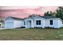 A modern home with a pristine white exterior, complemented by a lush lawn and tasteful landscaping at 37565 Teri Ct, Dade City, FL 33525