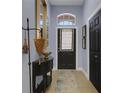 Inviting entryway featuring a black door with transom window, decorative console table, and elegant decor at 4425 Connery Ct, Palm Harbor, FL 34685