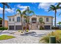 Stately home with a circular driveway, mature palms, and manicured landscaping at 6202 Pasadena Point Blvd, Gulfport, FL 33707