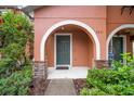 Charming covered front entrance with brick columns, welcome mat and green door with the house number above at 6831 Dartmouth Hill St, Riverview, FL 33578