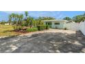 Home featuring a well-kept yard, mature trees, landscaping, and a long driveway at 736 85Th N Ave, St Petersburg, FL 33702