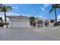 Inviting home with a two-car garage, low maintenance yard, mature palm trees, and an attractive gated entry at 927 Golf Island Dr, Apollo Beach, FL 33572