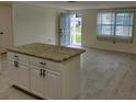 Bright living room with granite-topped kitchen island and tile floors at 10817 Fillmore Ave, Port Richey, FL 34668